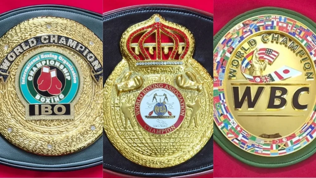 IBO world championship belt replica next to a WBC-style boxing belt, showing plate and strap comparison
